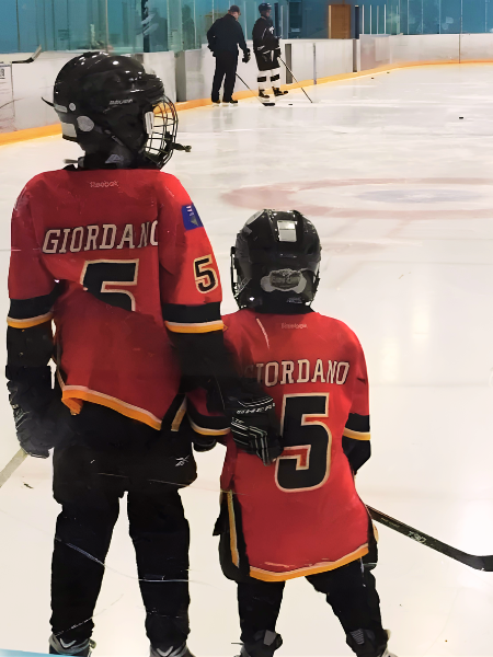 rochelle sons playing hockey in red jerseys